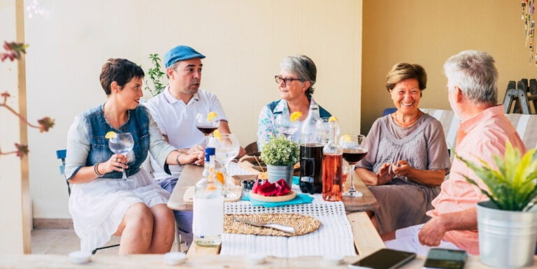Family Members Gathered Outdoors Discussing Dementia Care over Lunch at Memory Care Facility