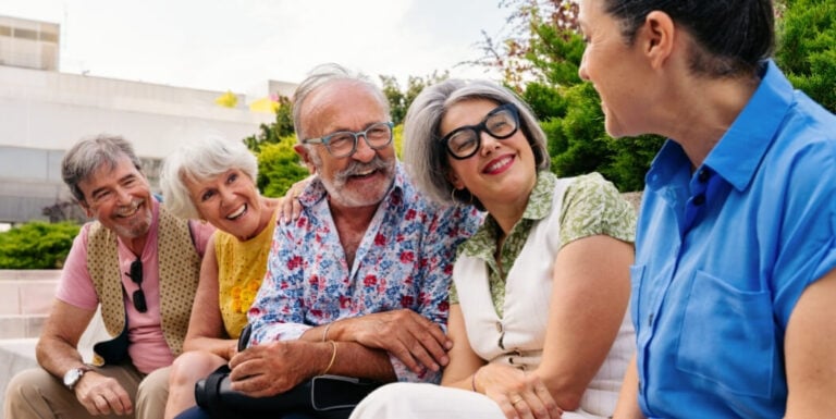 Elderly Friends Laughing Together Outdoors at Assisted Living Facility